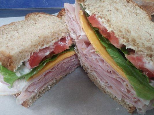 Country Ham sandwich - 1/4# shaved ham, smoked cheddar cheese, lettuce, tomato & homemade garlic mayo