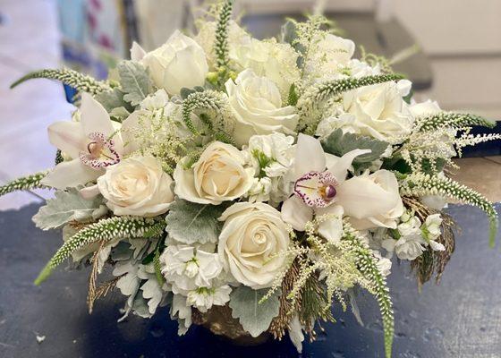 An elegant all white bouquet of flowers including roses, orchids and much more!