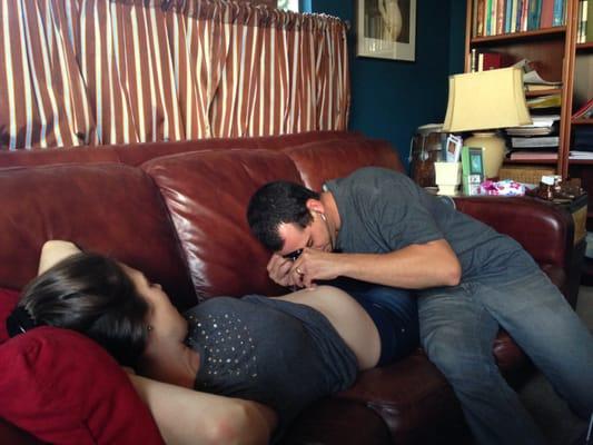 My husband listening to our baby's heartbeat with the fetoscope with Maggie and Caroline.