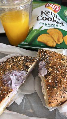 Freshly squeezed orange juice, bagel, and chips.