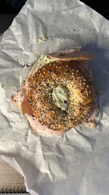 Everything smoked turkey bagel with pesto spread that was also toasted