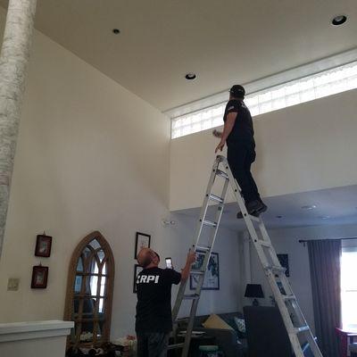 RPI remediation workers checking the ceiling below the leak with their water meter tool.