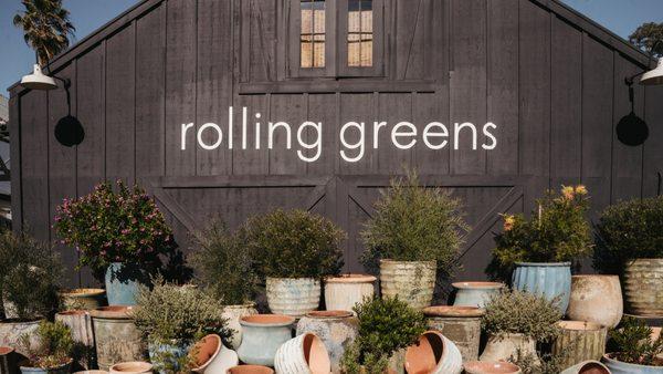 Front of the barn with various large exterior containers and pottery.