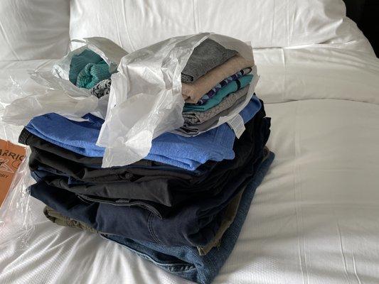 Jeans, scrubs, and T-shirt all neat and folded nicely with delicates wrapped in tissue.