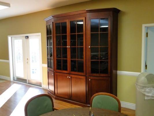 A large birch display unit with a burgundy stain. This is a single cabinet, not three individual units...