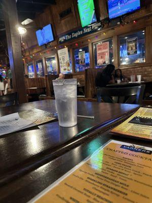 Tables with TVs in the room next to the bar