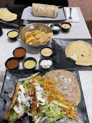 Crispy tacos and cheese pupusa, California burrito in the back.