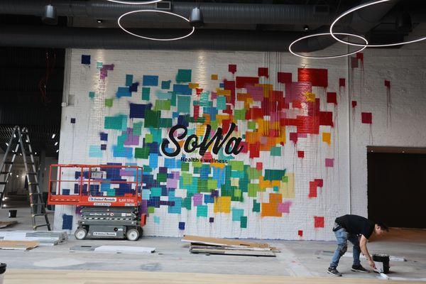 Flooring being installed in the Cardio Room under our mural by Blind Fox Art!