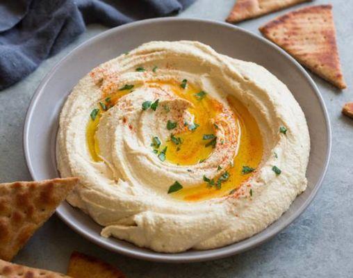 Hummus is a creamy dip or spread made from chickpeas, tahini, an acid, and sometimes olive oil