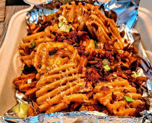 LOADED FRIES :Waffle Fries topped with Bacon, Chives, and Cheese. $13