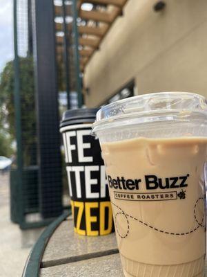 Outside sitting . Left drink is a Vanilla Bean Latte. Right drink is Iced Hazelnut Divinity.