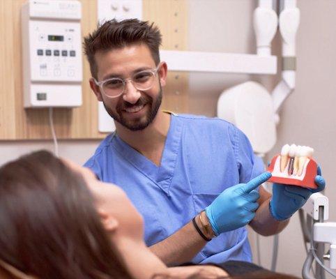 Dr. Jason Wilner explaining to a patient the process of replacing missing teeth with dental implants