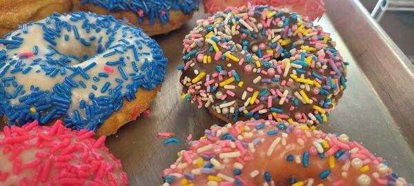 cake donuts with sprinkles on top. different flavor frosting.