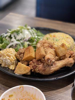 Fried drumsticks, fried rice and salad with a side of corn