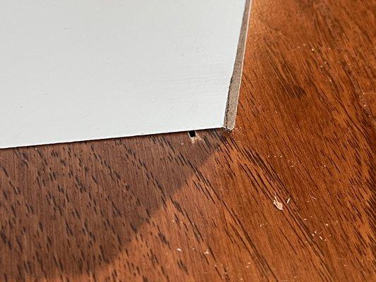 Hole in floor, baseboards don't meet square at corner