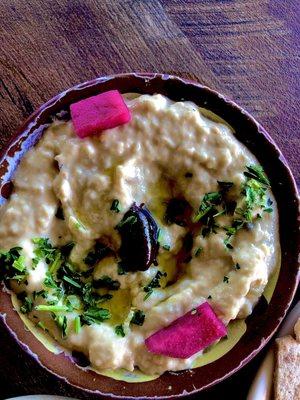 Baba Ghanouj is a dip of fire roasted eggplant, tahini, lemon juice, garlic, garnished with olive oil, olive and pickled turnips