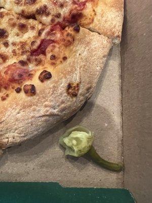 The eaten pepper beside our pizza.