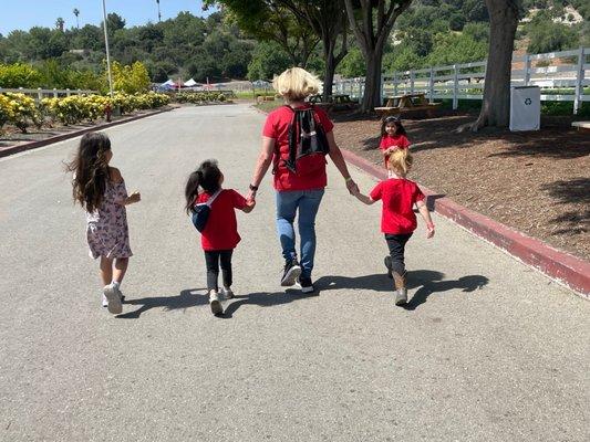 Mrs. Mitzie walking with the students to pick strawberries