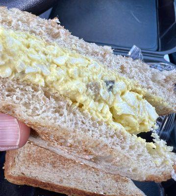 Detail of egg salad sandwich showing how thick spread is