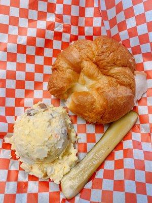 turkey croissant with potato salad and a pickle slice! super yummy