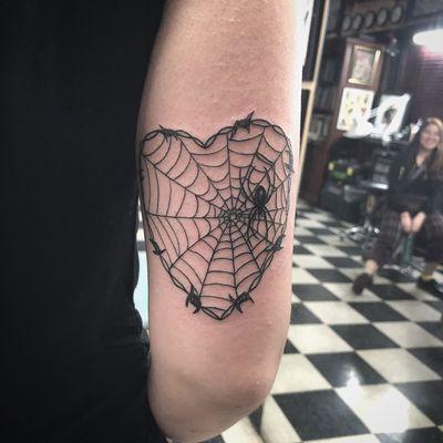 Spider web heart on the back of her arm.