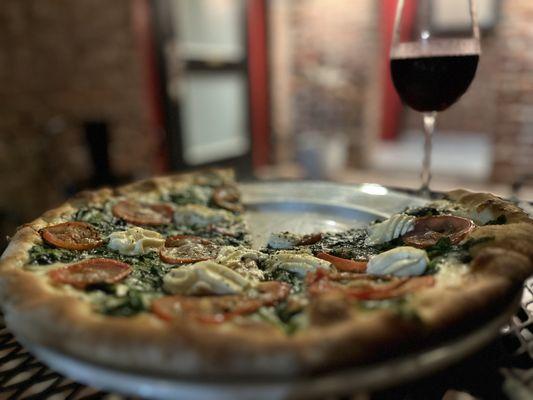 Pizza and glass of Cabernet in the courtyard. Spinach, Tomatoes, Garlic, and Ricotta pizza.