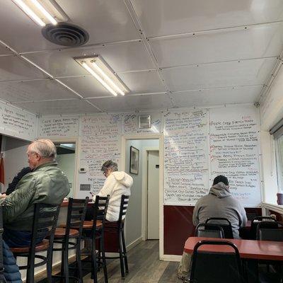 Interior: 7 AM Sunday morning at opening, customers begin to stream in. Menu illustrated on wall