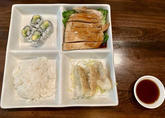 Bento box of California roll, hibachi chicken, rice, and pork gyoza