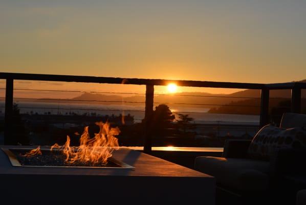 Relax on couches by the fire while enjoying the sunset over the San Juan Islands with delicious food and your favorite drink.