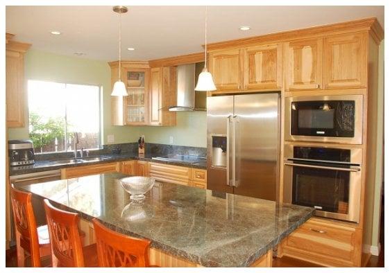 Kitchen cabinetry with raised Pecan wood panel doors in clear finish.