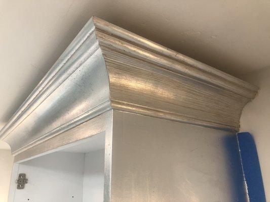 Silver leaf gilding on cabinetry.