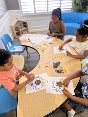 Art time: here the students are using ripped pieces of paper to create a mosaic-like sunflower.