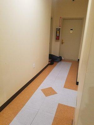 Homeless man sleeping in the hallway of 55 Madison street.