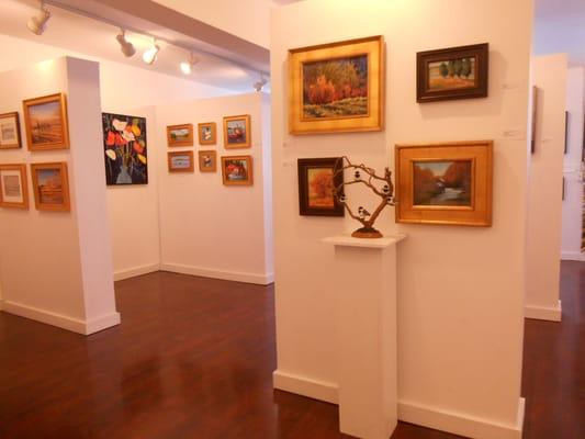 Works in the foreground by Suzanne deLesseps and carvings by Virginia Purcell, Bobbi Heath on the far wall in gold frames.