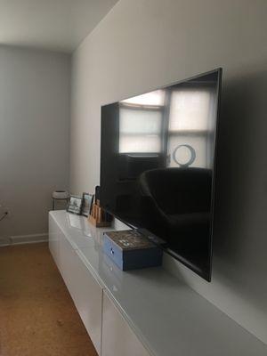 Installed 65" wall-mounted TV with recessed outlet box behind