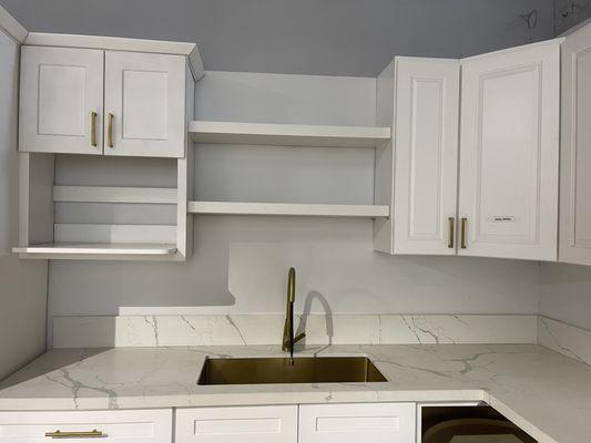 White Shaker cabinets with gold handles.