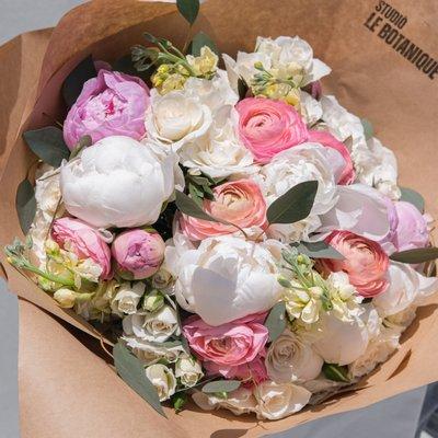 An explosion of soft colors befitting an English farmhouse come together in this charming bouquet with peonies, ranunculus, roses and more.