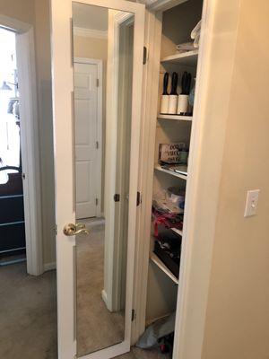 Full length mirror hidden on inside of closet door.