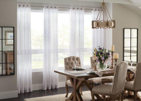 Sheer drapery panels with grommets in dining room.