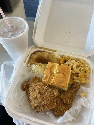 Fried chicken platter with mashed potatoes and gravy, mac and cheese, and cornbread. Sweet tea on the side.