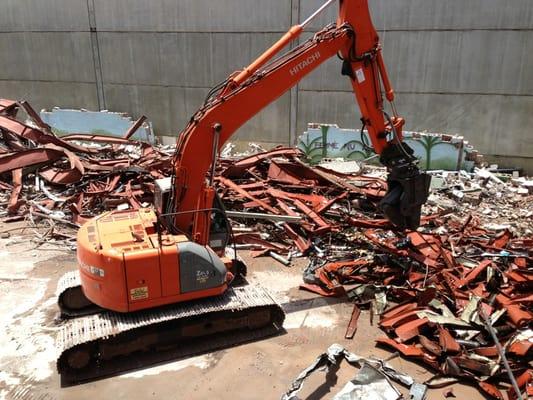 Processing scrap metal with hydraulic shears.