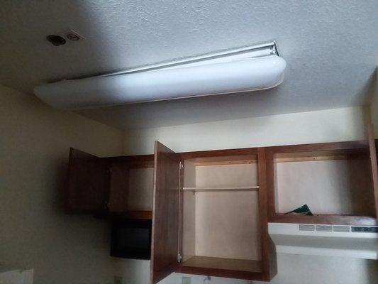 Broken light fixture and bare cabinets