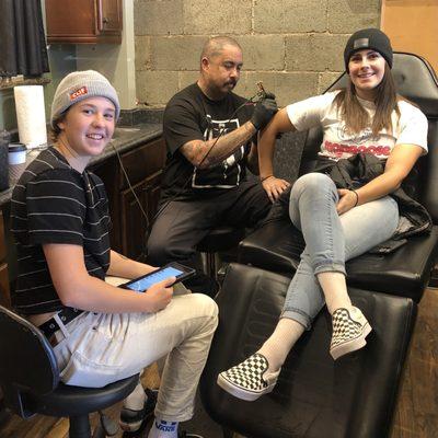 Tattooing professional BMX rider & Olympian, Nikita Ducarroz, while professional skateboarder & Olympian, Jordyn Barrett watches