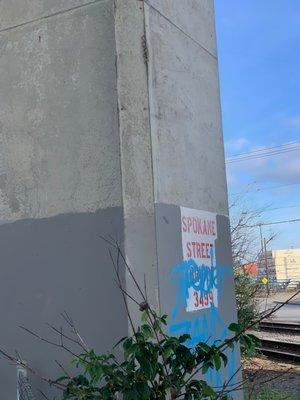 Vandalism over the Spokane Street Bridge sign/label at the bottom of the bridge.