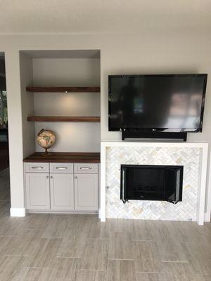 Calcutta herringbone tile with walnut flooring shelves and a contemporary mantle