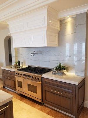 Amazing custom kitchen with dacor range and hood, stain and lacquer finish, marble countertops and backsplash with pot filler faucet.