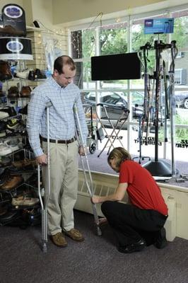 Megan Gill, our chief pharmacist, helps a man get fitted for crutches. These are one of the many types of equipment we offer.