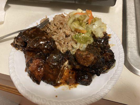 Jerk chicken, oxtail, rice and cabbage.