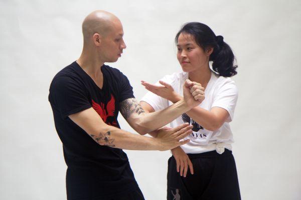 Canvas head Instructor "Dre" going over a Wing Tsun Chi Sau (sticking hands) drill with a student.