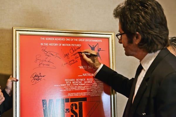 Academy Award winner, Golden Globe winner George Chakiris signs the West Side Story movie poster at the Ventura Film Festival